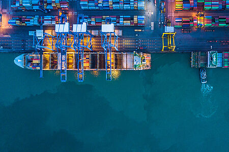 Eine Luftaufnahme von einem Containerschiff am Abend.
