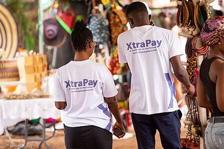 Zwei dunkelhäutige Menschen tragen ein Extra-Pay Shirt.